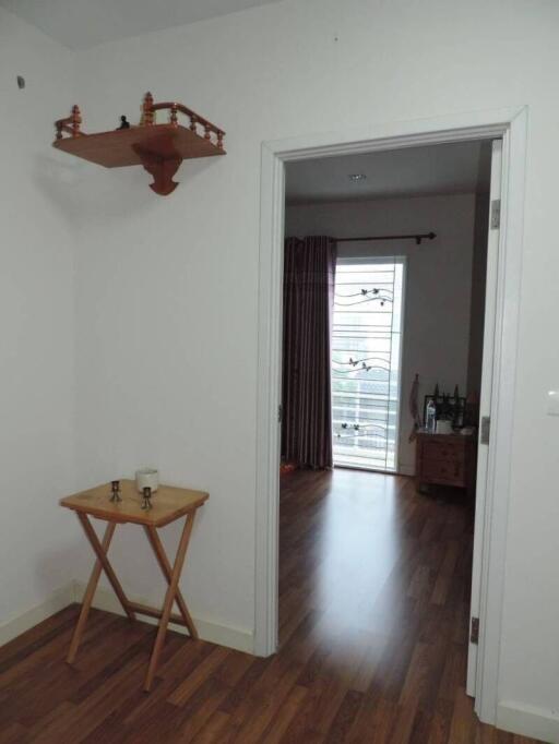 Bright and welcoming hallway leading to a living area with balcony access