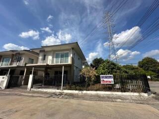 Suburban two-story house for sale under a clear blue sky