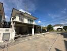 Two-story residential house with balcony and garage under a clear sky