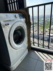 Washing machine on apartment balcony with urban background