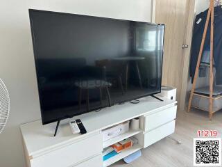 Modern living room with a large flat-screen television and minimalistic furniture