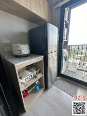 Compact kitchen area with modern appliances and balcony access