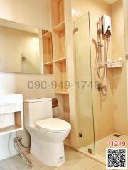 Modern bathroom with glass shower enclosure and wooden storage shelves