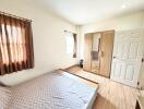 Spacious bedroom with natural light and wooden furnishings