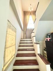 Brightly lit staircase with wooden steps and decorative curtain