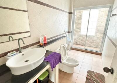 Spacious tiled bathroom with natural light