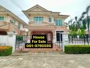 Front view of a two-story house with a for-sale sign