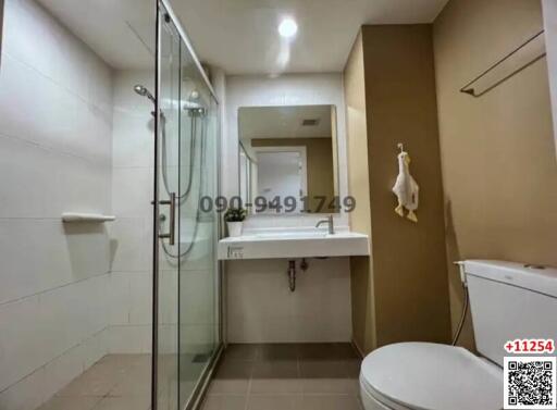 Modern bathroom interior with glass shower, white basin, and toilet