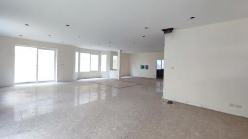 Spacious unfurnished living room with large windows and marble flooring