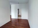 Spacious bedroom with hardwood floor and a view into the en-suite bathroom