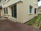 View of house exterior showing back yard with garden beds and a brick footpath