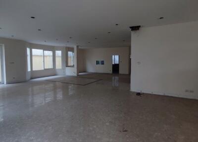 Spacious unfurnished living area with marble flooring and multiple windows