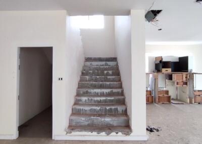 Under construction interior with unpainted walls and exposed staircase