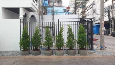 Modern building exterior with gated entrance and potted plants