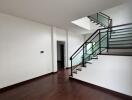 Spacious living area with wooden flooring and modern staircase