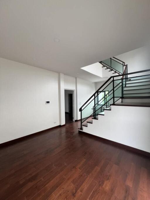 Spacious living area with wooden flooring and modern staircase