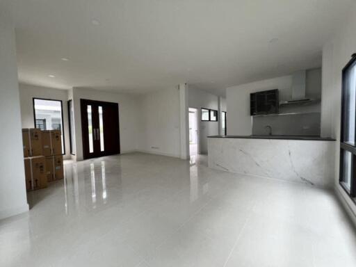 Spacious living room with glossy floor tiles and modern kitchen