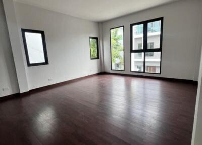 Spacious and empty living room with large windows and hardwood floors