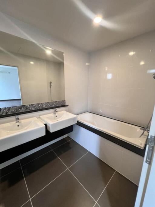Modern bathroom with dual sinks and bathtub