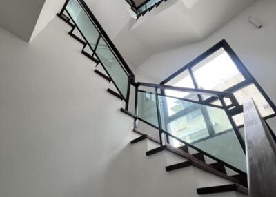 Modern staircase with glass balustrade and wooden steps in a bright interior