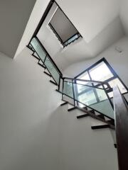 Modern staircase with glass balustrade and wooden steps in a bright interior