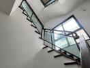 Modern staircase with glass balustrade and wooden steps in a bright interior