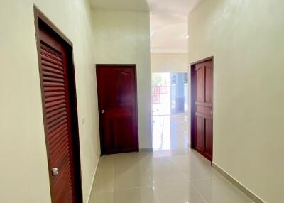 Brightly lit hallway with tiled flooring and multiple doors