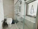 Modern bathroom with glass shower cabin and toilet