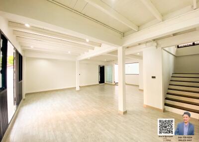 Spacious unfurnished interior of a house with high ceiling and staircase