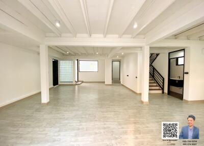 Spacious unfurnished interior of a bright living space with white beams and wooden flooring