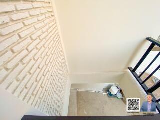 Stairwell with white brick wall and black banister
