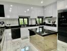 Modern kitchen with white cabinets, black countertops, and state-of-the-art appliances
