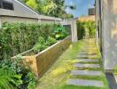 Lush garden pathway beside a modern house with stepping stones