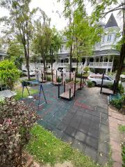 Victorian style house exterior with lush greenery and playground