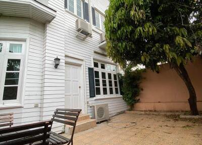 White multi-story residential building with a shaded patio area