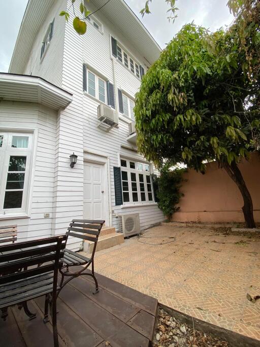 White multi-story residential building with a shaded patio area