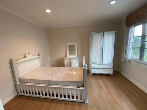 Spacious bedroom with a large bed and wooden wardrobe