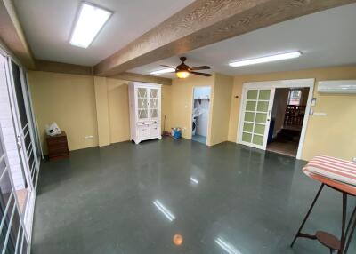 Spacious living room with glossy tiled flooring and multiple doors