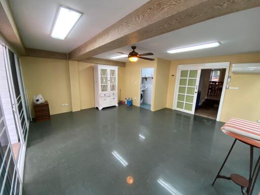 Spacious living room with glossy tiled flooring and multiple doors