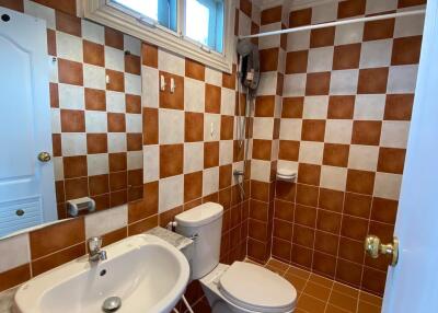 Compact bathroom with checkered wall tiling and modern fixtures