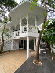 Two-story house with balcony and outdoor seating area