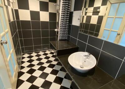 Black and white tiled bathroom with shower and sink