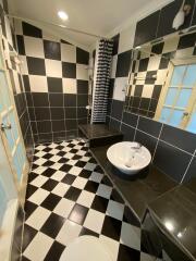 Black and white tiled bathroom with shower and sink