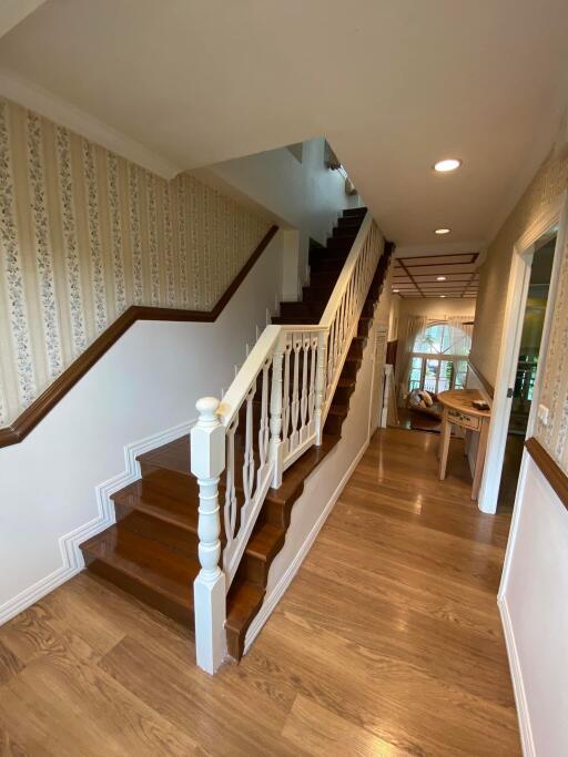 Elegant hallway with wooden staircase and hardwood floors