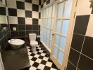 Black and white tiled bathroom with large windows