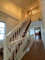 Elegant wooden staircase with white balusters and warm lighting