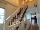 Elegant wooden staircase with white balusters and warm lighting