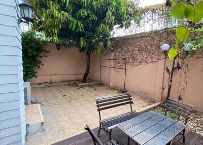 Cozy outdoor patio with seating area and greenery