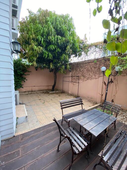 Cozy outdoor patio with seating area and greenery