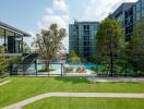 Modern outdoor pool area with lush greenery and adjacent building